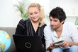 a couple doing internet near a globe