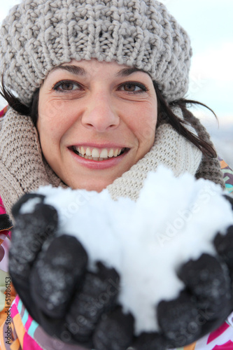 Photo: woman all smiles at ski resort with snow in hands woman all smiles at ski resort with snow in hands