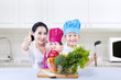Foto: Chef vegetarian kids and mom give thumbs up at home Chef vegetarian kids and mom give thumbs up at home