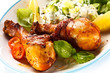 Grilled chicken legs and vegetables on white background
