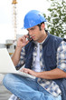 Foto: Construction worker with computer and phone Construction worker with computer and phone