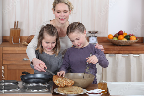 Photo: Mum and girls making pancakes Mum and girls making pancakes