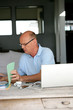 Foto: Senior man trying to sort hiss house bills out Senior man trying to sort hiss house bills out