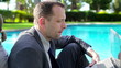 Business couple working with laptop and smartphone by the pool