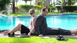 Video: Business couple with laptop and tablet relaxing by the pool Business couple with laptop and tablet relaxing by the pool