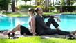 Happy business couple relaxing by the swimming pool