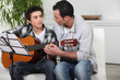 Foto: father and teenage son playing the guitar father and teenage son playing the guitar
