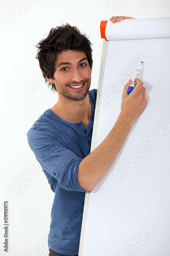 Photo: young man writing with marker on a white board young man writing with marker on a white board