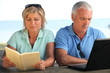 Foto: Young couple with book and computer Young couple with book and computer