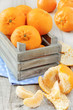 Delicious mandarins oranges in a crate on wooden surface