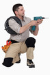 Photo: Tradesman holding up an electric screwdriver Tradesman holding up an electric screwdriver