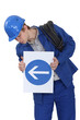 Photo: A road worker holding an arrow sign. A road worker holding an arrow sign.