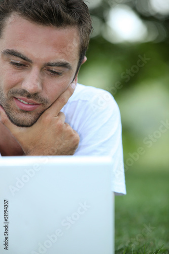 Photo: Using his laptop in park Using his laptop in park