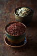 Red, brown and wild rice in ceramic dishes