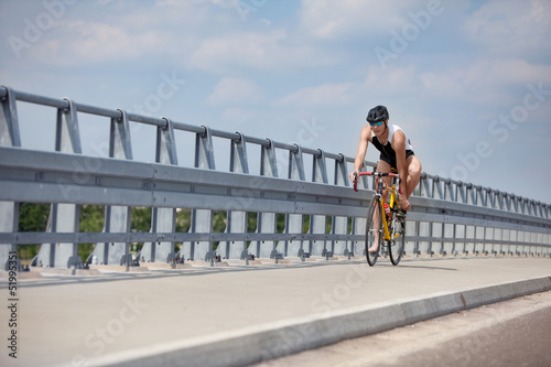 Photo: triathlete - biker starting riding on race bike triathlete - biker starting riding on race bike