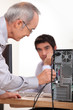 Photo: Man plugging a cable into the back of a hard drive Man plugging a cable into the back of a hard drive