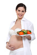 Photo: Pregnant woman holding plate of fruit Pregnant woman holding plate of fruit