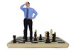 Stressed businessman standing on giant chess board