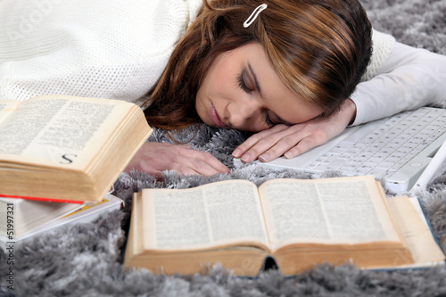 Photo: female student sleeping amid books female student sleeping amid books