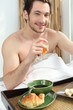 Photo: Man having breakfast in bed Man having breakfast in bed