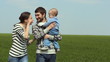 family walking on green grass and smiling 