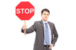 A businessman holding a stop sign