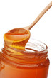 Honey dripping from a wooden honey dipper isolated on white back