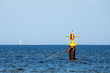 Yellow mooring buoy in a calm bay in the Baltic sea.