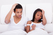 Foto: Worried Couple Holding Pregnancy Tester Worried Couple Holding Pregnancy Tester