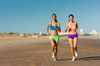 Sport and Fitness - people jogging on beach