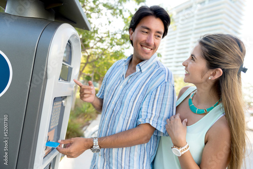 Photo: Couple paying for parking Couple paying for parking