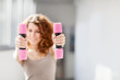 Young woman doing exercise with dumbbells