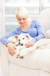 Woman sitting with young dog on the sofa