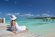 Girl on the wooden jetty looking to the ocean. Exuma, Bahamas