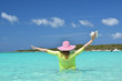 Girl with a seashell in the turqouise water of Atlantic. Exuma,