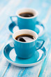 Photo: Vertical shot of two turquoise espresso cups on wooden boards Vertical shot of two turquoise espresso cups on wooden boards