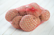 Sack of raw potatoes on wooden boards