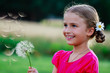 Foto: Summer joy - lovely girl blowing dandelion Summer joy - lovely girl blowing dandelion