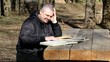 Student reading a book outdoors on a bench