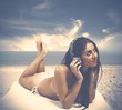 Photo: Girl listens to music at the beach Girl listens to music at the beach
