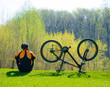 Cyclist Sitting on the Grass Near His Bike