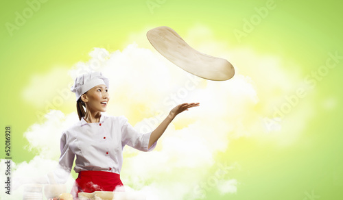 Photo: Asian female cook making pizza Asian female cook making pizza