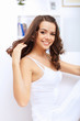 Young pretty woman in white at home