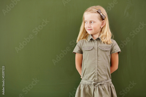Photo: Scoolgirl standing near blackboard Scoolgirl standing near blackboard