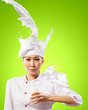 Photo: Asian female cook against milk splashes Asian female cook against milk splashes