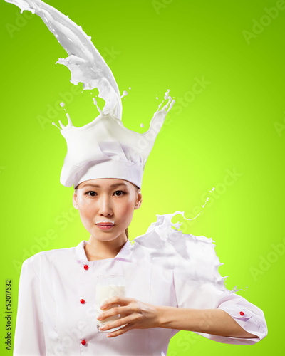 Photo: Asian female cook against milk splashes Asian female cook against milk splashes