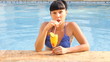 beautiful woman relaxing in swimming pool with cocktails