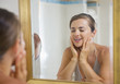 Foto: Happy young woman washing face in bathroom Happy young woman washing face in bathroom