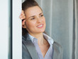 Dreamy business woman near window looking into distance