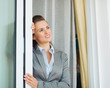 Dreamy business woman near window looking into distance